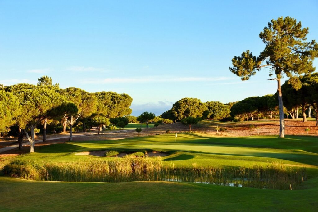 Pinhal golf course green beside water at dusk in Vilamoura, Portugal